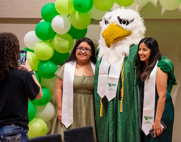 First gen students pose with Scrappy under a balloon arch