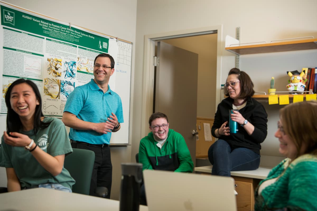 Students, faculty and staff sit in a group