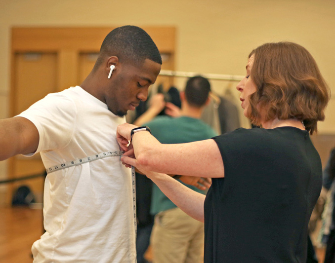 A student at the Suit Up Closet event gets measured for a suit