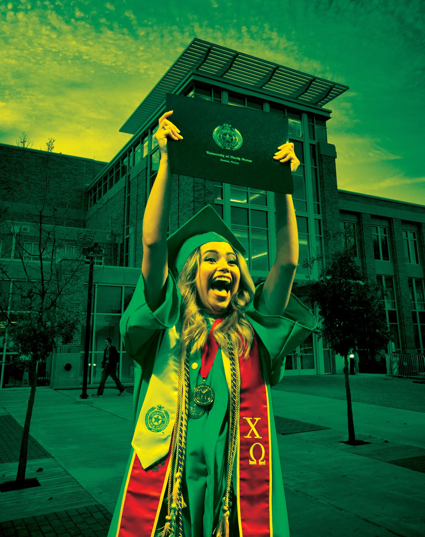 Graduate raising diploma above their head